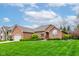 Beautiful brick home featuring lush green lawn and landscaping with an attached two-car garage and driveway at 691 Walnut Woods Dr, Greenwood, IN 46142