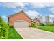 Brick home with attached two-car garage, concrete driveway and walkway surrounded by well-manicured landscaping at 691 Walnut Woods Dr, Greenwood, IN 46142