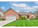 Charming brick home with a well-manicured lawn, beautiful landscaping, and an attached two-car garage at 691 Walnut Woods Dr, Greenwood, IN 46142