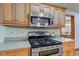 Kitchen features stainless gas range and oven, microwave and granite counters and wood cabinets at 691 Walnut Woods Dr, Greenwood, IN 46142