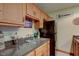 Basement kitchenette with wooden cabinets, black appliances, and granite countertops at 691 Walnut Woods Dr, Greenwood, IN 46142