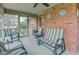 Inviting screened porch with ample seating and brick accents, ideal for enjoying the outdoors at 691 Walnut Woods Dr, Greenwood, IN 46142