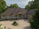 Aerial view of a well-maintained home with a large driveway and mature trees surrounding the property at 9943 Irishman'S Run Ln, Zionsville, IN 46077