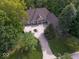 Aerial view of home surrounded by mature trees, featuring a circular driveway and brick exterior at 9943 Irishman'S Run Ln, Zionsville, IN 46077