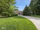 Lush front lawn leading to a charming brick home with a covered entryway at 9943 Irishman'S Run Ln, Zionsville, IN 46077