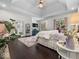 A bright main bedroom with hardwood floors, a tray ceiling, sitting area, and natural light from the nearby windows at 9943 Irishman'S Run Ln, Zionsville, IN 46077