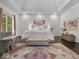 A spacious main bedroom with hardwood floors, a tray ceiling, and soft, natural light from the nearby windows at 9943 Irishman'S Run Ln, Zionsville, IN 46077