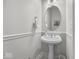 Elegant powder room with a pedestal sink, decorative mirror, and stylish fixtures at 9943 Irishman'S Run Ln, Zionsville, IN 46077