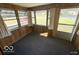 Bright sun room surrounded by windows with paneled walls and neutral carpeting at 234 Ringwood Way, Anderson, IN 46013