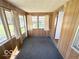 Enclosed sun room with wood-paneled walls, neutral carpet and views to the street at 234 Ringwood Way, Anderson, IN 46013