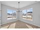 Bright dining area with large windows, modern chandelier, and wood-look flooring at 16920 Cattle Hollow Ln, Noblesville, IN 46060