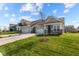 New construction, a lovely gray home with a two-car garage and a freshly planted tree in the front yard at 16920 Cattle Hollow Ln, Noblesville, IN 46060