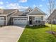 Charming gray home featuring a two-car garage and a well-manicured lawn on a sunny day at 16920 Cattle Hollow Ln, Noblesville, IN 46060