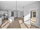 Open-concept living room with hardwood floors, modern light fixture, and stainless steel appliances at 16920 Cattle Hollow Ln, Noblesville, IN 46060