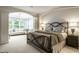 Comfortable bedroom features an iron bed frame, sitting area with chandelier, and large windows at 729 Greenford N Trl, Carmel, IN 46032