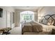 Serene bedroom with a decorative iron bed frame, seating area, and ample natural light at 729 Greenford N Trl, Carmel, IN 46032
