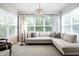Bright living room with large windows, a modern chandelier, and an L-shaped sofa at 729 Greenford N Trl, Carmel, IN 46032