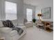 Bright living room with neutral tones, featuring a comfortable chair, desk, and plenty of natural light from the windows at 729 Greenford N Trl, Carmel, IN 46032