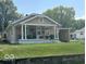 Charming single story home with a covered front porch, lawn, and an American flag at 217 Ringwood Way, Anderson, IN 46013