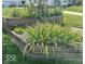 Close up of a yard with flower beds and a retaining wall along the edge of the lawn at 217 Ringwood Way, Anderson, IN 46013