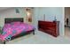 Neutral carpeted bedroom featuring a dark wood dresser and black upholstered headboard on the bed at 7932 Eagle Valley Pass, Indianapolis, IN 46214