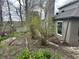Lush backyard featuring brick chimney with greenery and flower bed in need of some TLC at 7934 S 600 W, Edinburgh, IN 46124
