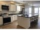 Modern kitchen with stainless steel appliances, island with seating, and ample cabinet space, great for entertaining guests at 2729 Massachusetts Ave, Indianapolis, IN 46218