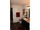 Well-lit bathroom with a granite countertop, classic vanity, and coordinating red accessories at 882 Brookshire Dr, Franklin, IN 46131