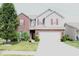 Charming two-story home featuring a manicured lawn, brick accents, and attached two-car garage at 882 Brookshire Dr, Franklin, IN 46131