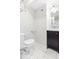 Modern bathroom featuring a toilet, vanity with sink, and sleek white tile flooring at 1817 Bellefontaine St, Indianapolis, IN 46202