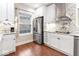 Modern kitchen featuring white cabinets, stainless steel appliances, tile backsplash, and hardwood floors at 1817 Bellefontaine St, Indianapolis, IN 46202
