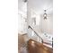 Hallway and stairway with hardwood floors, black handrail, and views to a window seat at the bottom of the stairs at 1817 Bellefontaine St, Indianapolis, IN 46202