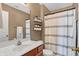 Neutral toned bathroom featuring a white vanity, decorative shelves and a shower with a striped curtain at 828 Ashton Park Dr, Greenwood, IN 46143