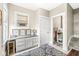 Bright bathroom with built-in cabinets, granite countertop, blue rug, and adjacent powder room at 1019 Central Ave, Indianapolis, IN 46202