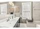 Bathroom showcasing double sinks, decorative backsplash and art, and a tub/shower at 1019 Central Ave, Indianapolis, IN 46202