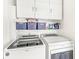 Laundry room with washer, dryer, storage cabinets and shelf with storage baskets at 1019 Central Ave, Indianapolis, IN 46202