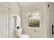 Bathroom featuring a toilet next to a large window with views of a landscaped backyard at 22 W 54Th St, Indianapolis, IN 46208