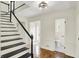 Welcoming foyer featuring hardwood floors, a staircase with black accents, and access to a half bathroom at 22 W 54Th St, Indianapolis, IN 46208