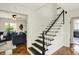 Welcoming foyer showcasing hardwood floors, a staircase with black accents, and views into the living room at 22 W 54Th St, Indianapolis, IN 46208