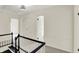 Upstairs hallway featuring carpet flooring, white trim and doors, and a black handrail adds a modern touch at 22 W 54Th St, Indianapolis, IN 46208