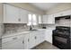 Modern kitchen featuring white cabinets, stainless steel appliances, and stylish backsplash at 120 Hugo St, Indianapolis, IN 46229