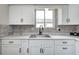 Well-lit kitchen featuring a stainless steel sink, white cabinets, and plenty of counter space at 120 Hugo St, Indianapolis, IN 46229