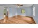 Spacious bedroom with hardwood floors, light blue walls, ceiling fan, and two windows at 4807 Graceland Ave, Indianapolis, IN 46208