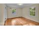 Bedroom featuring refinished hardwood floors and abundant natural light from two windows at 4807 Graceland Ave, Indianapolis, IN 46208