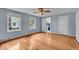 Bright bedroom with refinished hardwood floors, two windows, and a ceiling fan at 4807 Graceland Ave, Indianapolis, IN 46208