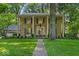 Charming stone-faced home with a manicured lawn, mature trees, and covered front porch with stately columns at 4807 Graceland Ave, Indianapolis, IN 46208