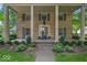 Inviting stone home with covered front porch, stately columns, and manicured landscaping welcomes visitors at 4807 Graceland Ave, Indianapolis, IN 46208