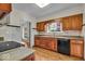 Classic kitchen featuring wood cabinets, laminate countertops, and black appliances at 4807 Graceland Ave, Indianapolis, IN 46208