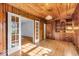 Living room with wood paneling, hardwood floors, built-in cabinet, and glass doors at 4807 Graceland Ave, Indianapolis, IN 46208