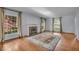 Cozy living room with fireplace, hardwood floors, oriental rug, and natural light from the expansive windows at 4807 Graceland Ave, Indianapolis, IN 46208